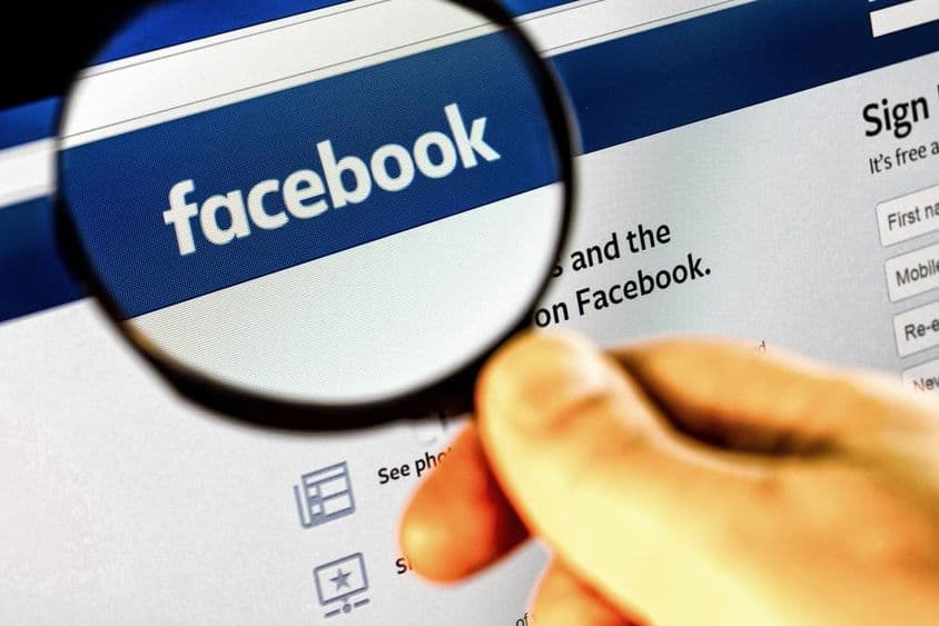 Captura de pantalla de la página de inicio de Facebook en un monitor a través de una lupa.