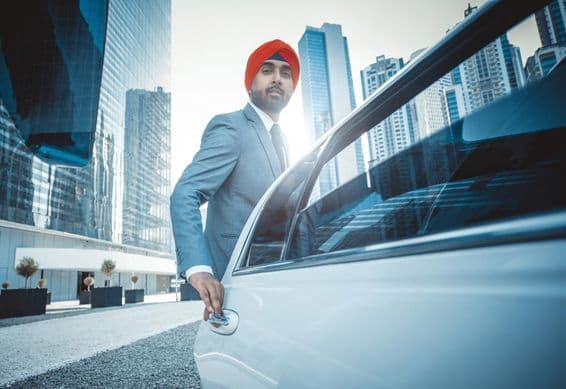 Empresario indio con coche de empresa en Dubái.