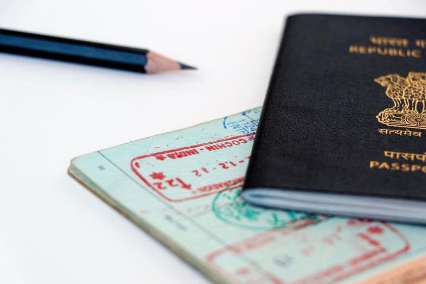 Emiratos Árabes Unidos y sellos oficiales indios en una página de pasaporte, en árabe e hindi.