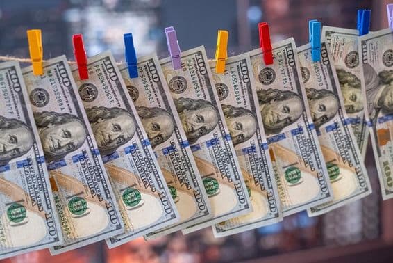 Un billete de 100 dólares colgando de un tendedero con pinzas de madera.