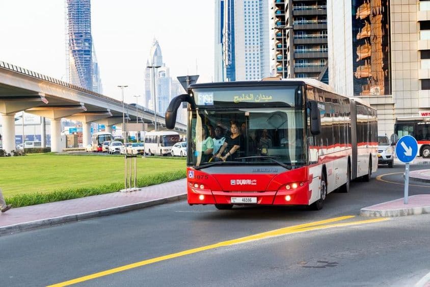 Autobús de Dubái y moderno rascacielos a lo largo de Sheikh Zayed Road.