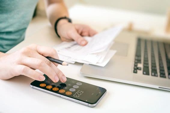 ABU DHABI, Mujer gestionando gastos usando una calculadora.