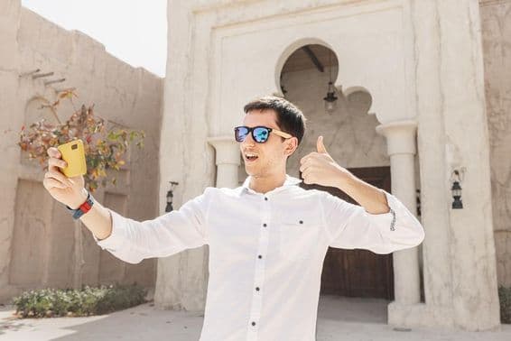 Hombre grabando un videoblog en el antiguo distrito de Bur Dubai Creek.