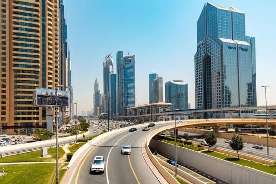 Vista de Sheikh Zayed Road con rascacielos y puente de autopista en primer plano.