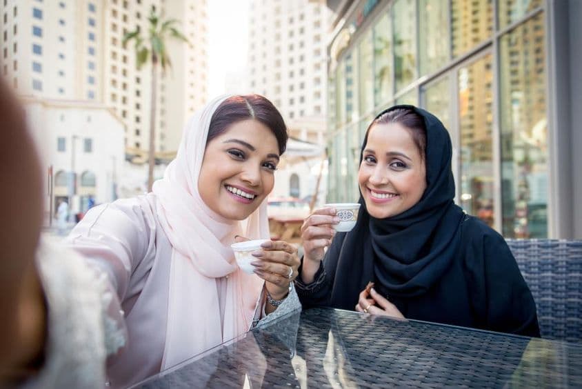Mujeres árabes disfrutando de café al aire libre en Dubái.