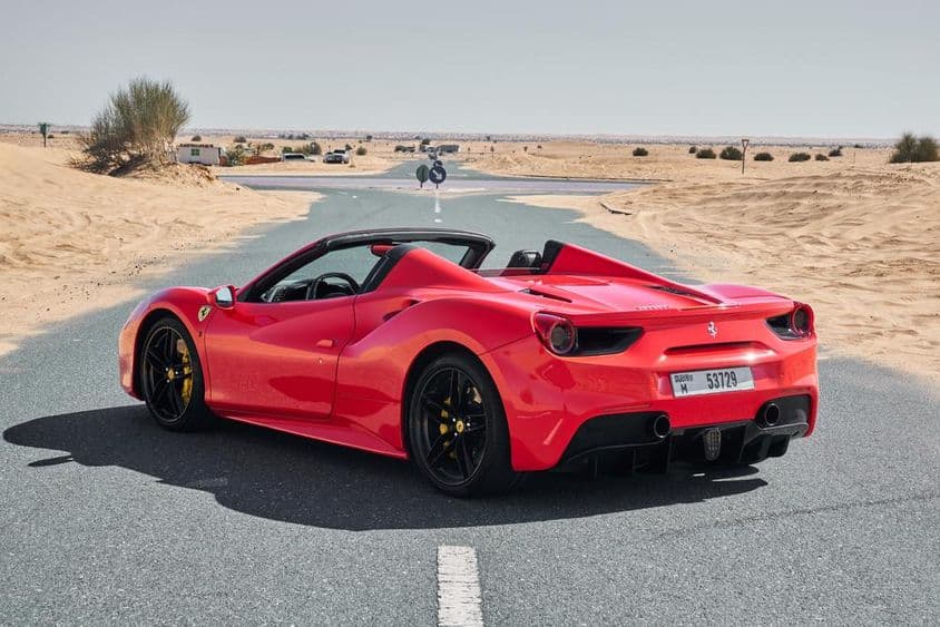 Ferrari 488 rojo en una carretera desierta de Dubái.
