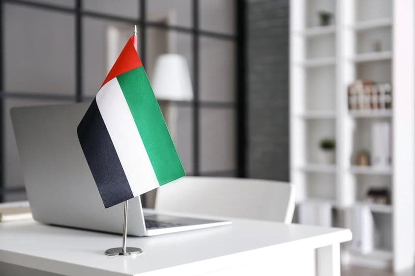 Bandera de los Emiratos Árabes Unidos sobre una mesa en una oficina moderna.