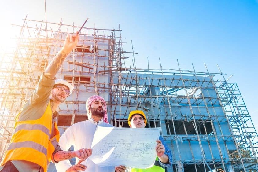Equipo de ingeniería inspecciona planos de construcción en un sitio de obra.