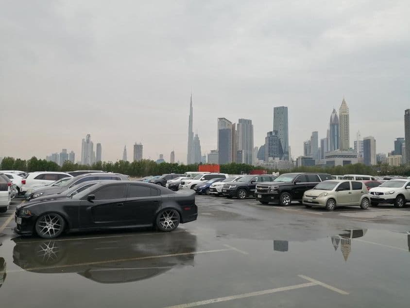 Secuelas de la lluvia en un área de estacionamiento cerca del Centro de Comercio Mundial de Dubai y el Burj Khalifa.