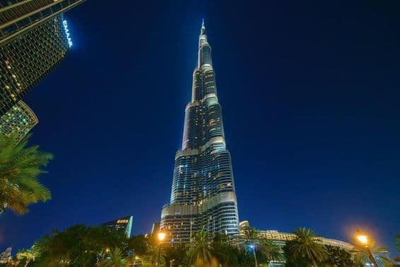 Vista panorámica de la torre Burj Khalifa desde abajo, de noche.