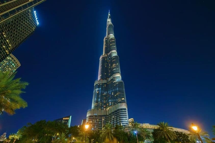 Vista panorámica de la torre Burj Khalifa desde abajo, de noche.