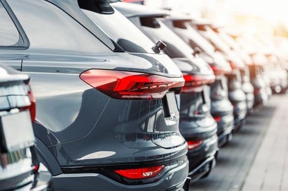 Vista trasera de una flota de carros SUV modernos nuevos en el estacionamiento de un concesionario.