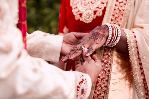 La mano de una novia india recibiendo un anillo.