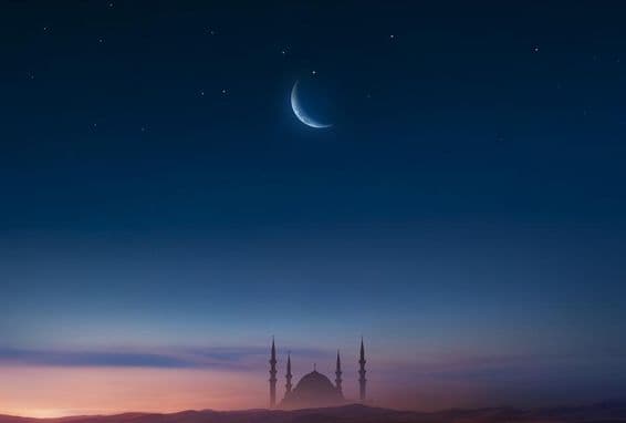 Mezquita al atardecer con luna en el cielo.