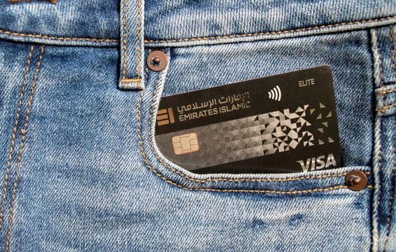 Tarjeta Visa plástica del Emirates Islamic Bank en el bolsillo delantero de unos jeans.