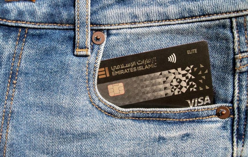 Tarjeta Visa plástica del Emirates Islamic Bank en el bolsillo delantero de unos jeans.
