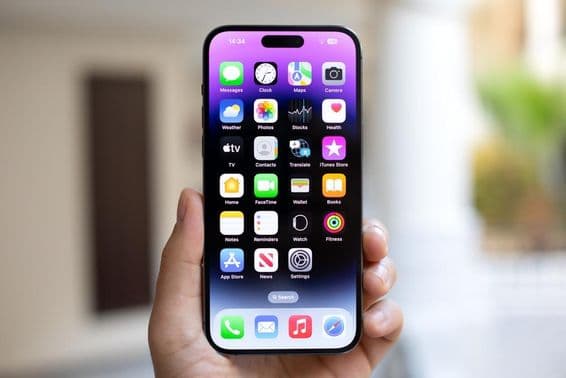 Hombre sosteniendo un iPhone 15 Pro Max con iOS 17 en la pantalla.
