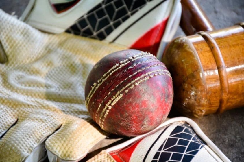Equipo de cricket, pelota, guante y bate.