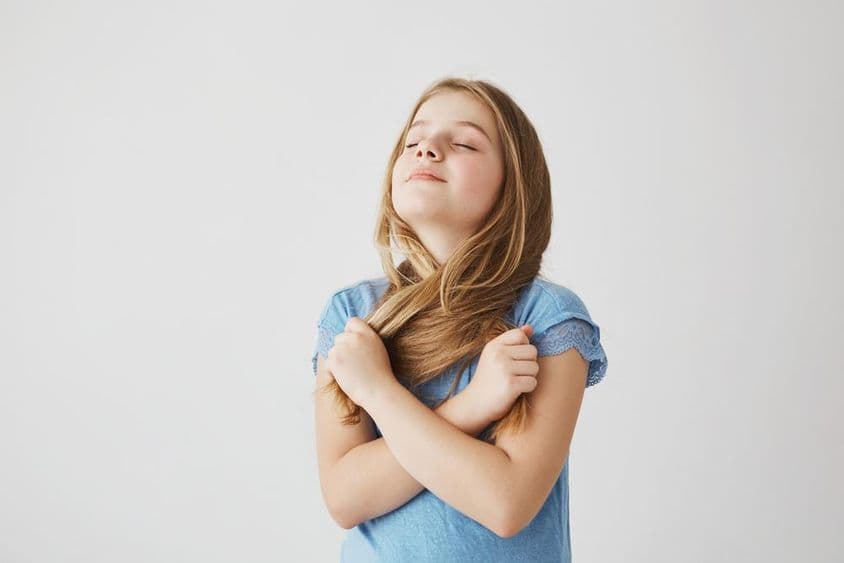 Niña rubia respira profundamente aire fresco.