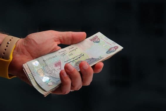 Emiratos Árabes Unidos, dirham de Dubai en la mano de un hombre.