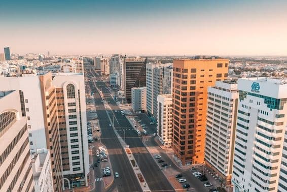 Abu Dhabi, vista aérea de una amplia calle con tráfico pasando entre rascacielos.