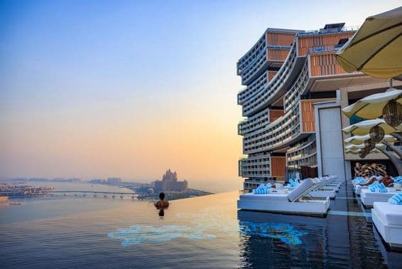 Puesta de sol sobre una piscina infinita con vista a Palm Jumeirah en Atlantis Royal.