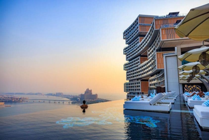 Puesta de sol sobre una piscina infinita con vista a Palm Jumeirah en Atlantis Royal.