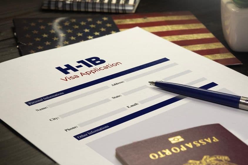 Aplicación de visa H-1B de EE.UU. sobre la mesa con un pasaporte.