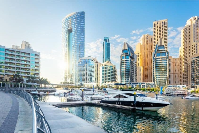 Una impresionante vista de Dubai Marina con modernos edificios y yates en el agua.