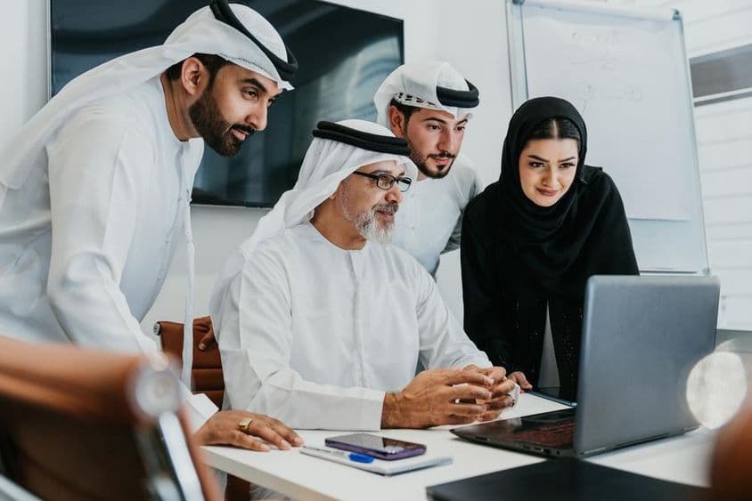 Un grupo de empresarios corporativos del Medio Oriente con atuendos tradicionales emiratíes.