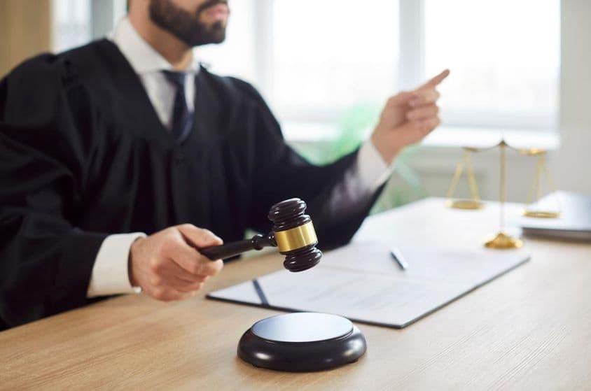 El juez golpea el martillo y el tribunal dicta un fallo en la sala del tribunal.