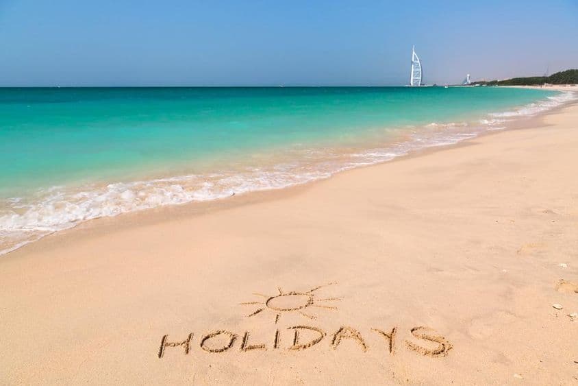 Cartel de vacaciones en una playa con agua turquesa.
