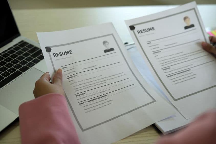 Una joven gerente de RRHH asiática leyendo un currículum.