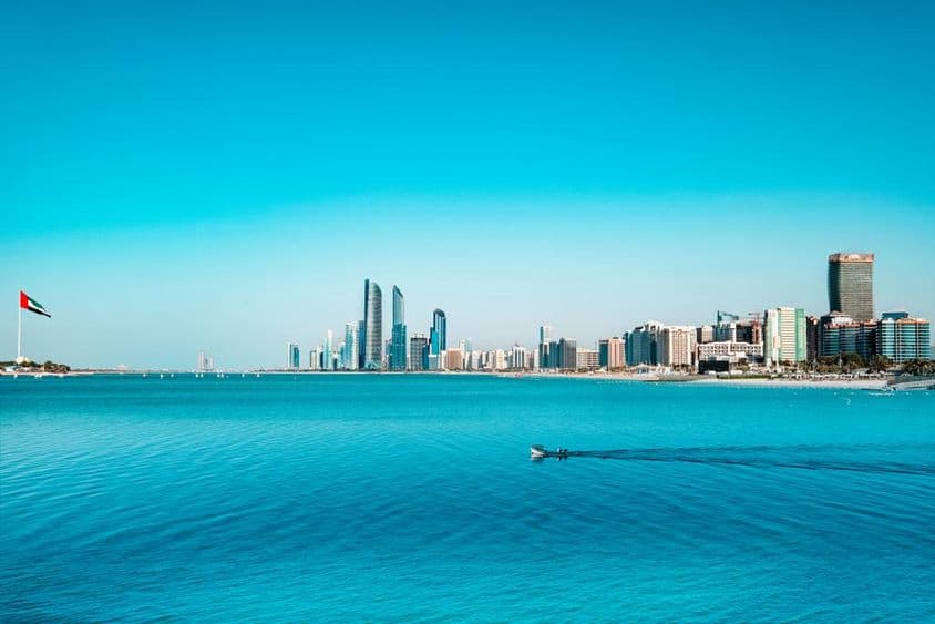 Vista del litoral de Abu Dabi con un bote de pesca cruzando.