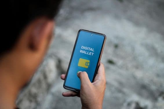 La mano de una persona mostrando la interfaz de aplicaciones de billetera digital en la pantalla de un teléfono inteligente.