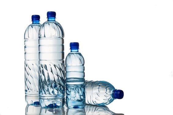 Cuatro refrescantes aguas minerales naturales en botellas de plástico.