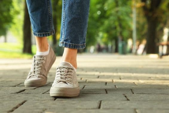 Mujer caminando con elegantes zapatillas por una calle de la ciudad.