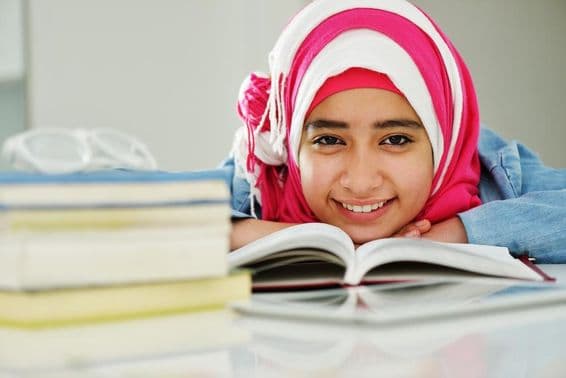 Hermosa chica musulmana árabe leyendo en la universidad.