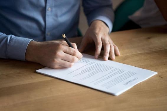 Empresario firmando un contrato a mano.