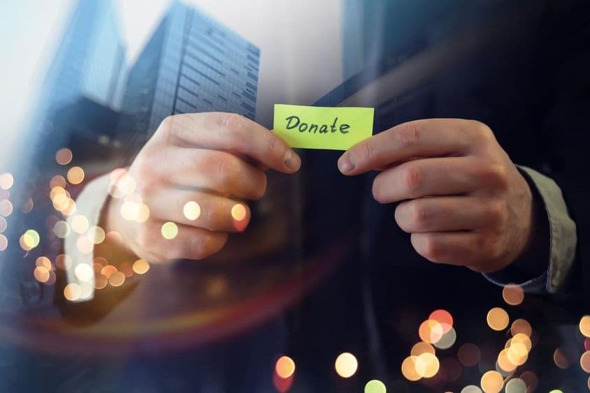 Empresario mostrando un documento con la palabra 'donación'.