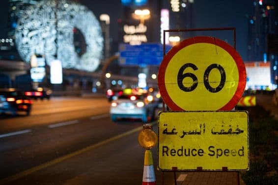 Autopista de Dubái por la noche con límite de velocidad máximo.