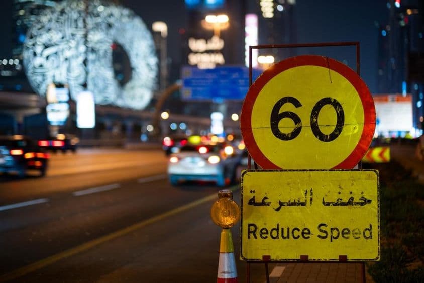 Autopista de Dubái por la noche con límite de velocidad máximo.