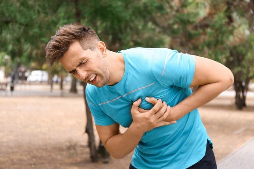 Joven sufriendo un ataque cardíaco mientras corre en el parque.