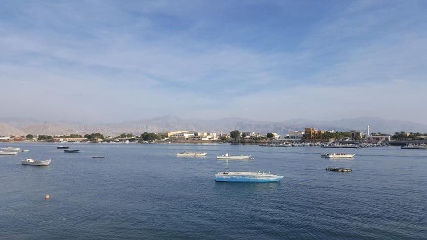 Bahía de Ras Al Khaimah con mar azul y cielo nublado.
