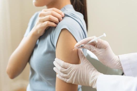 Un doctor administrando una vacuna a un paciente en una clínica.