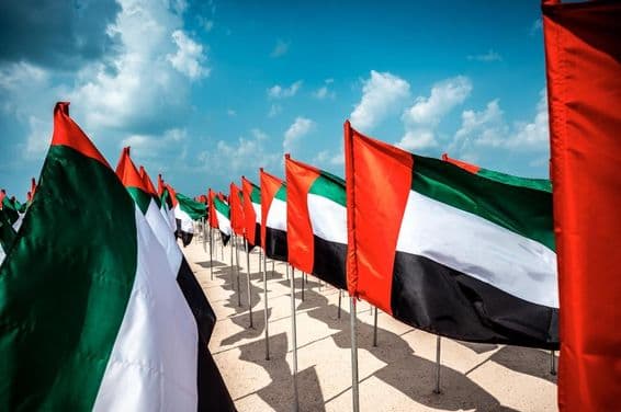 Banderas de los Emiratos Árabes Unidos ondeando al viento en una popular playa de Dubái.