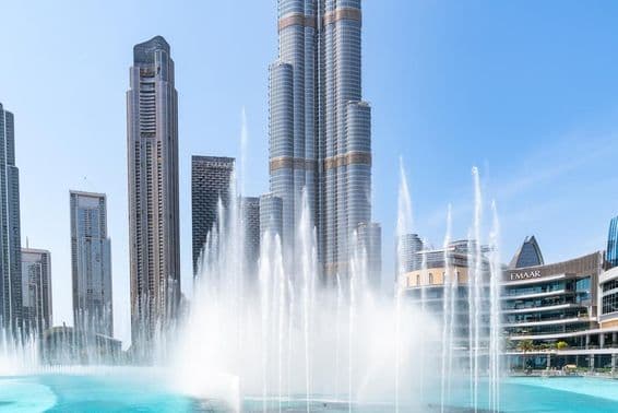 Vista de la Fuente de Dubái y el rascacielos Burj Khalifa en un día soleado en Dubái.
