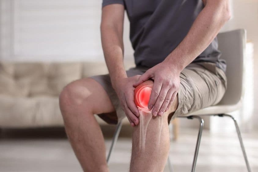 Hombre sufriendo de dolor de rodilla.