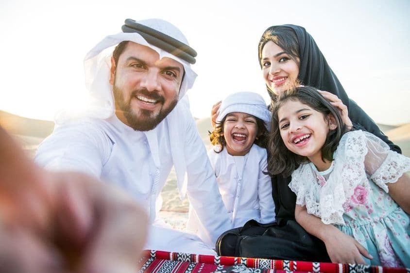 Familia feliz disfrutando de un día maravilloso en el desierto haciendo un picnic.