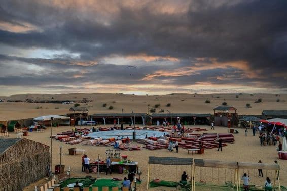 Puesta de sol sobre un campamento beduino tras safaris tradicionales en Dubái.